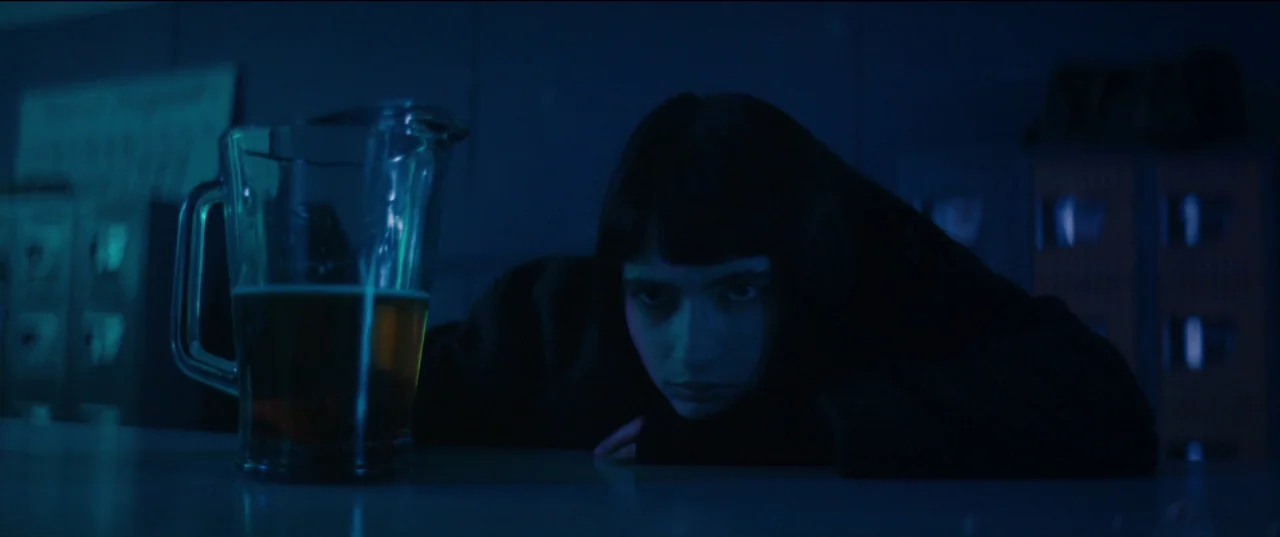 Humanist Vampire Seeking Consenting Suicidal Person (2023) movie still: medium — A dimly lit interior with a dark blue color cast and lockers in the…