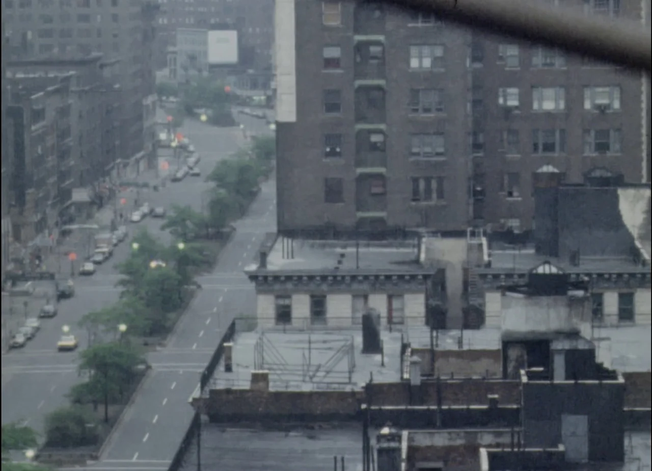 Hotel Monterey (1973) movie still: establishing — An urban city street viewed from an elevated perspective during an overcast day. Brick apartment…