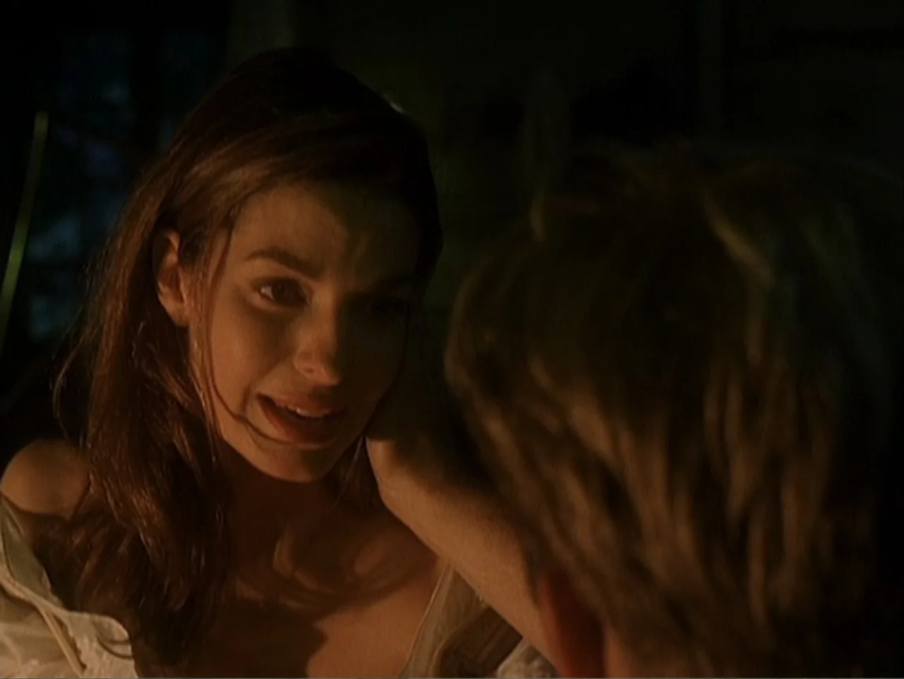 Catch a Falling Star (2000) movie still: closeup — A dark interior setting at night with a close-up on the woman's face. The woman observes the man…