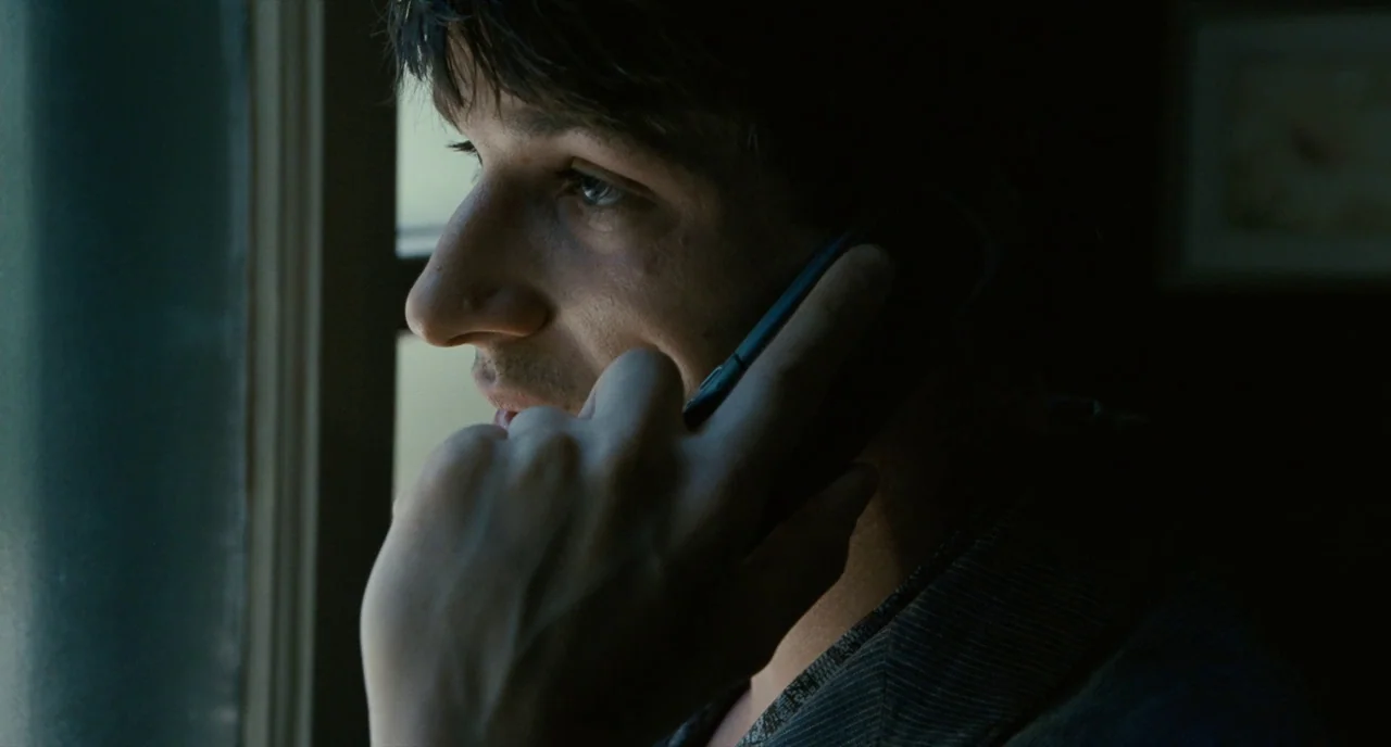 It’s Only The End Of The World (2016) movie still: closeup — A dark, dim room with a window providing the only light source on the subject. A young…