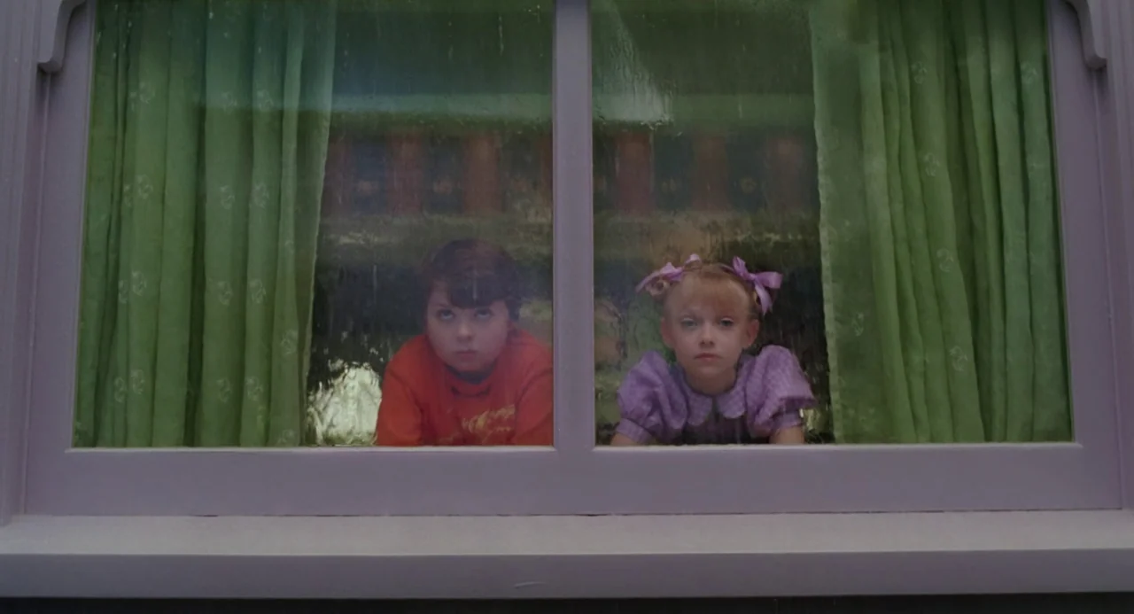 The Cat In The Hat (2003) movie still: medium — A white-framed residential window has green curtains on either side. A young girl and a young boy…
