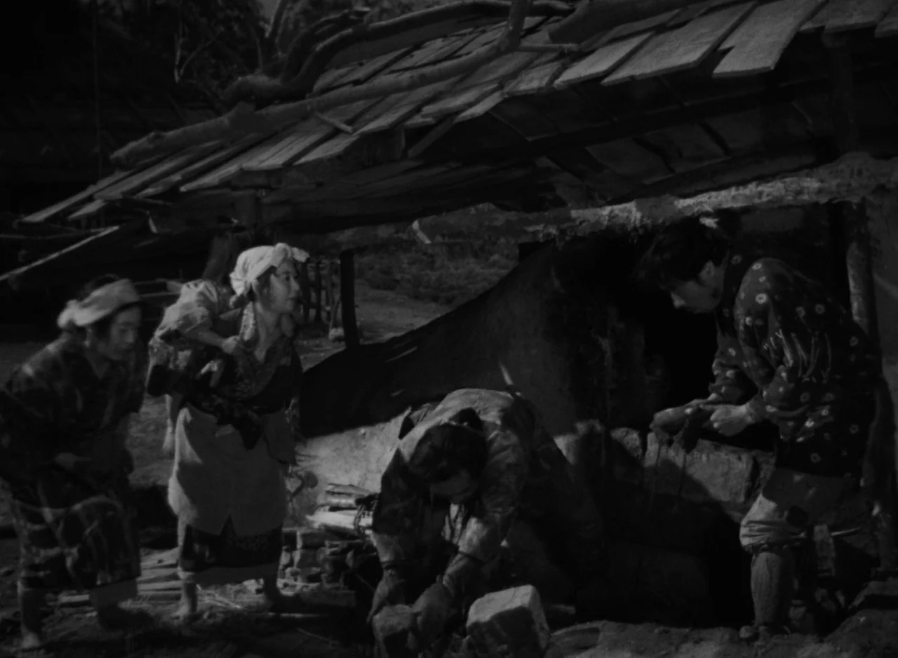 Ugetsu (1953) movie still: fullbody — A group of people works near a makeshift wooden and mud-walled hut structure. The scene is set in an…