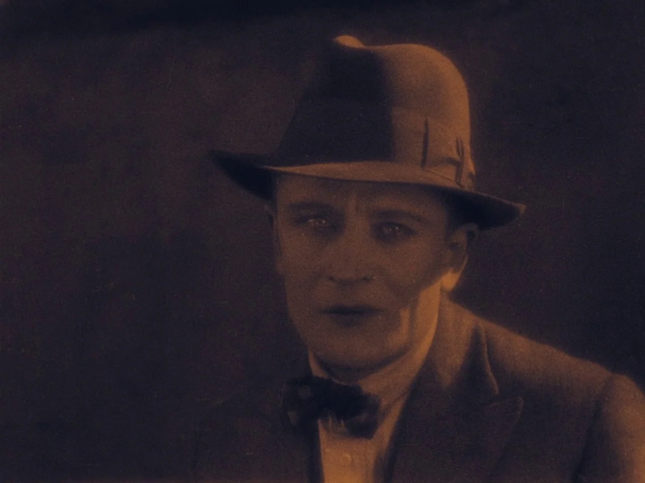 The Lodger (1927) movie still: closeup — A dark, undifferentiated interior setting with minimal environmental detail visible behind the subject. A…