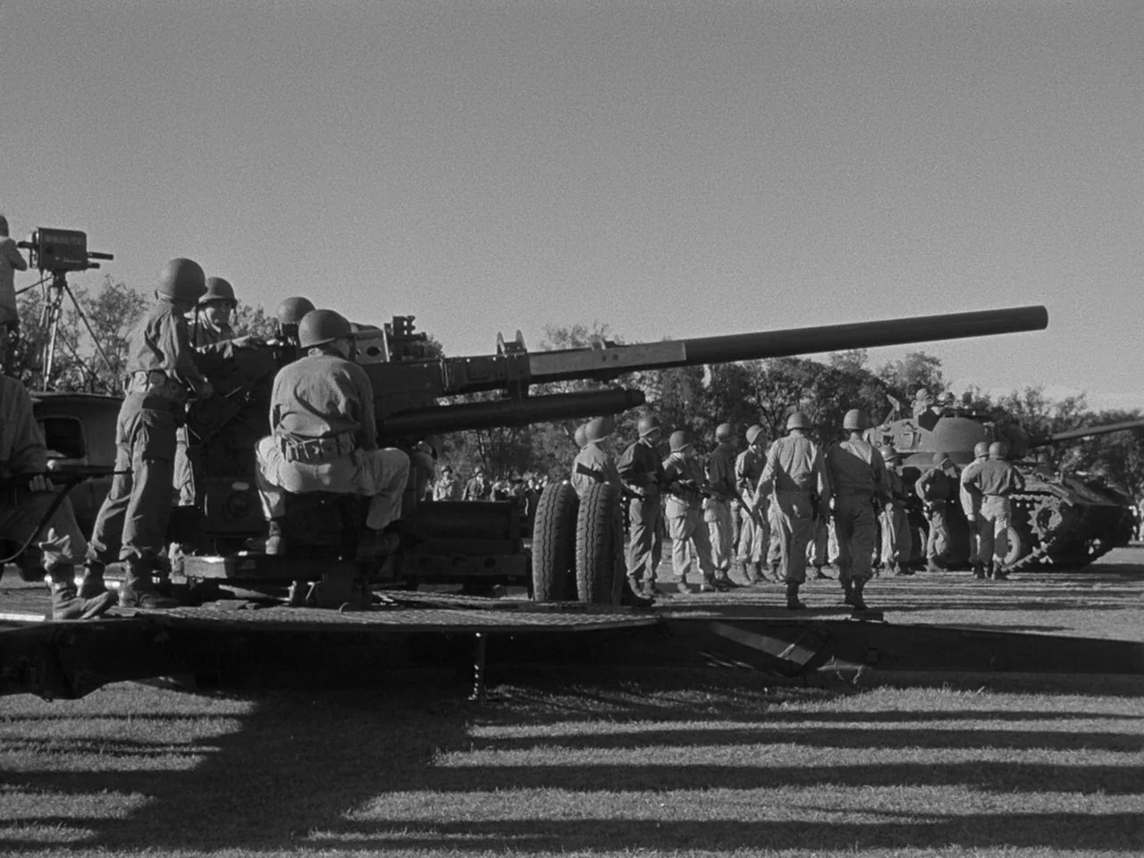 The Day the Earth Stood Still (1951) movie still: wide — A field filled with American soldiers training around a large anti-aircraft cannon unit.…