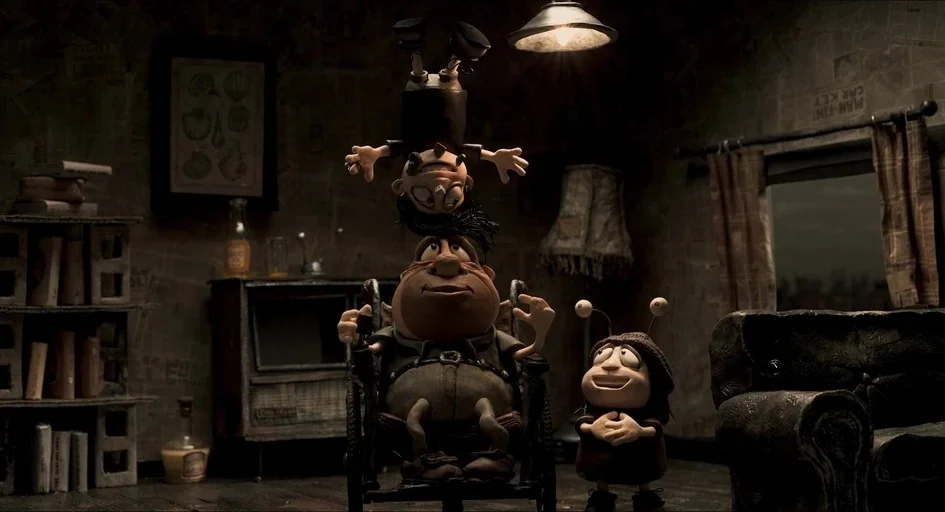 Memoir of a Snail (2024) movie still: medium — A dimly lit room with walls covered in textured paper and a small bookshelf. An adult in a wheelchair…