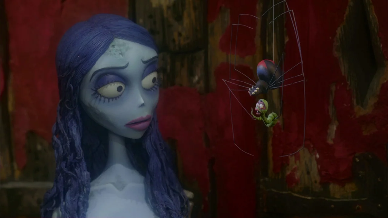The Corpse Bride (2005) movie still: medium — A dark, textured room features decaying red fabric draped over wooden panels behind the subjects. A…