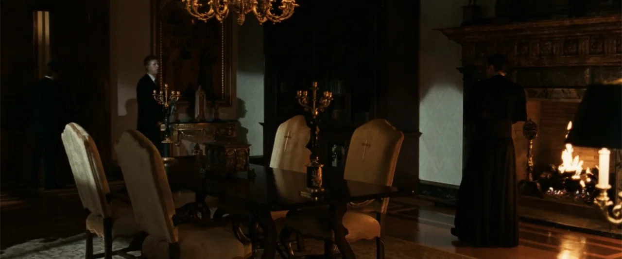 Angels & Demons (2009) movie still: wide — A dark, elegant wood-paneled room features a large dining table and fireplace. Several men in formal…