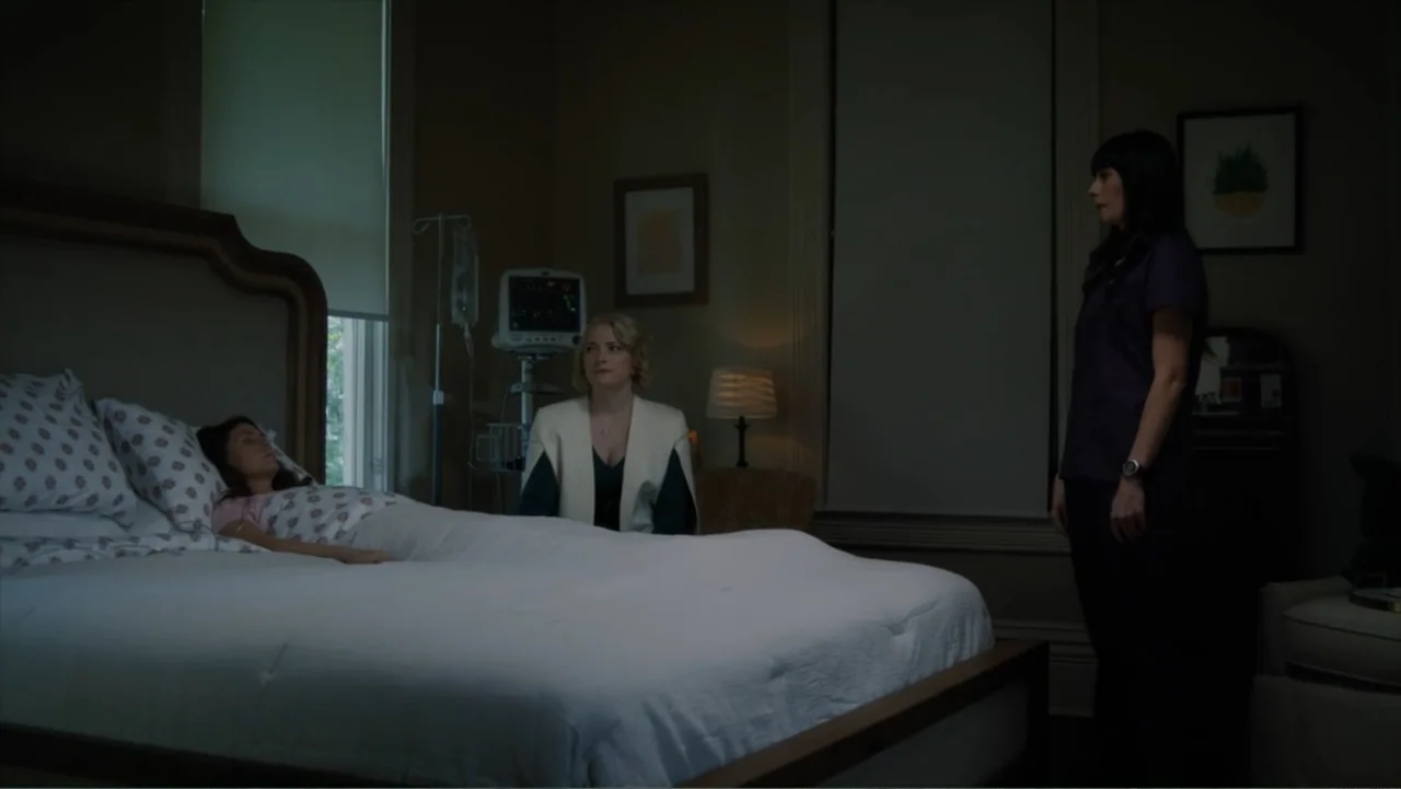 Storm Damage (2000) movie still: medium — A medical room features a patient bed, a medical monitor, and framed artwork. Three women are present in…