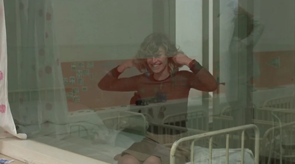 Don’t Look Now (1973) movie still: medium — A hospital ward featuring white metal-framed cribs and a wall decorated with small photos. A young woman…