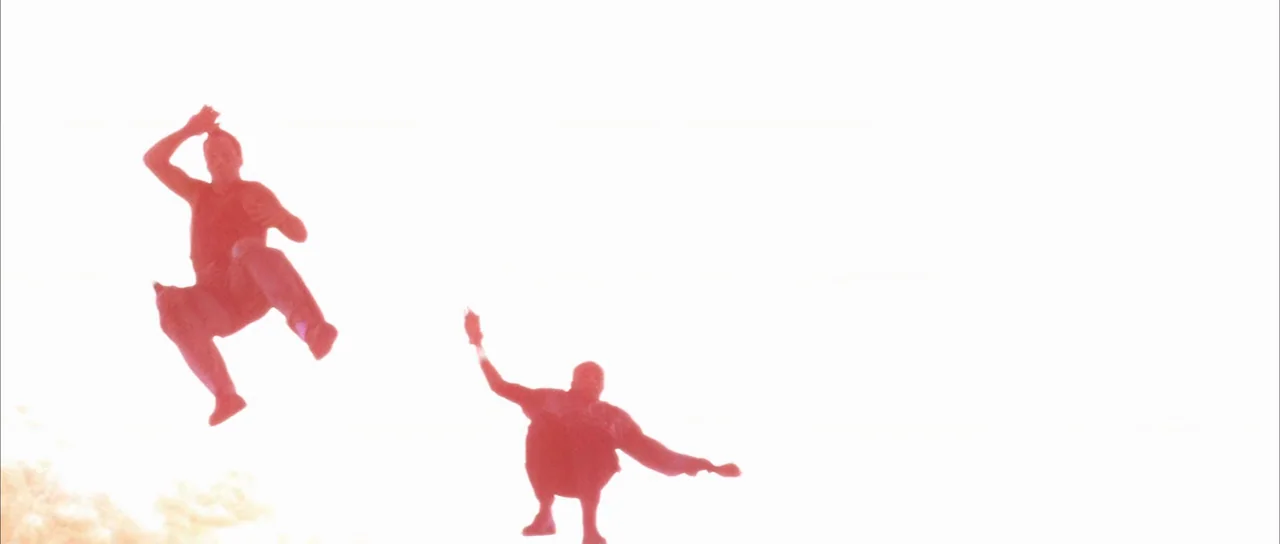 Die Hard with a Vengeance (1995) movie still: wide — Two figures are frozen in mid-air against an extremely bright, overexposed white outdoor…