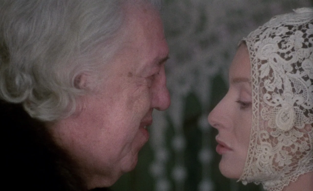 Blanche (1971) movie still: closeup — An interior space features two figures positioned face-to-face in a close proximity shot. An elderly man and a…