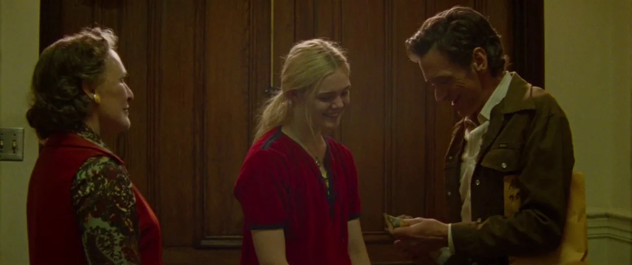 Low Down (2014) movie still: medium — An interior space features dark wood paneling with an ornate door. Three people interact with one another…