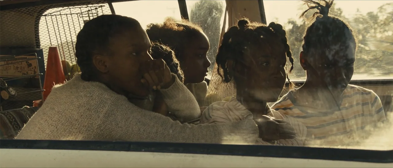 King Richard (2021) movie still: medium — Four children sit in the back of a vehicle looking out the window. Bright light floods the space from the…