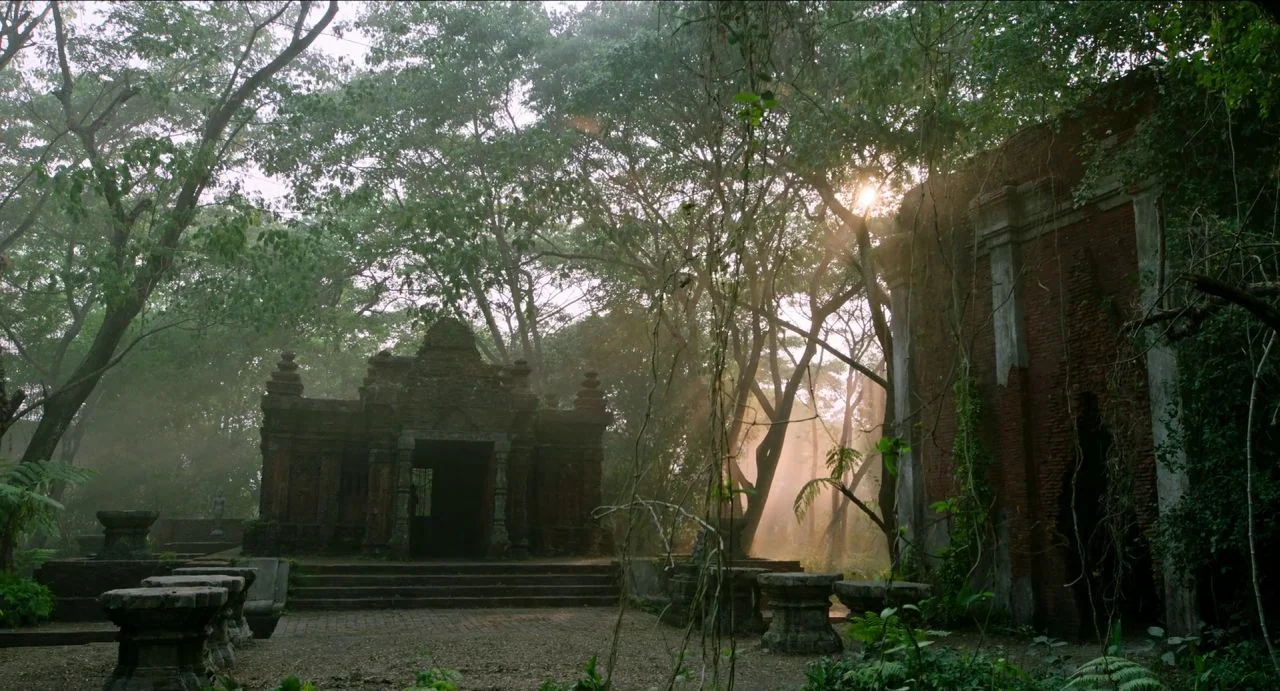 Da 5 Bloods (2020) movie still: establishing — An ancient weathered brick structure stands abandoned within a dense, misty, overgrown forest…