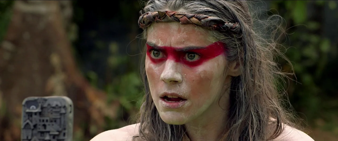 Green Inferno (2013) movie still: closeup — A dense green jungle setting with blurred foliage visible in the out-of-focus background. A young woman…