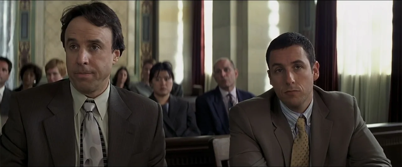 Anger Management (2003) movie still: medium — A courtroom features wood-paneled walls and rows of seated observers in the background. Two men in…