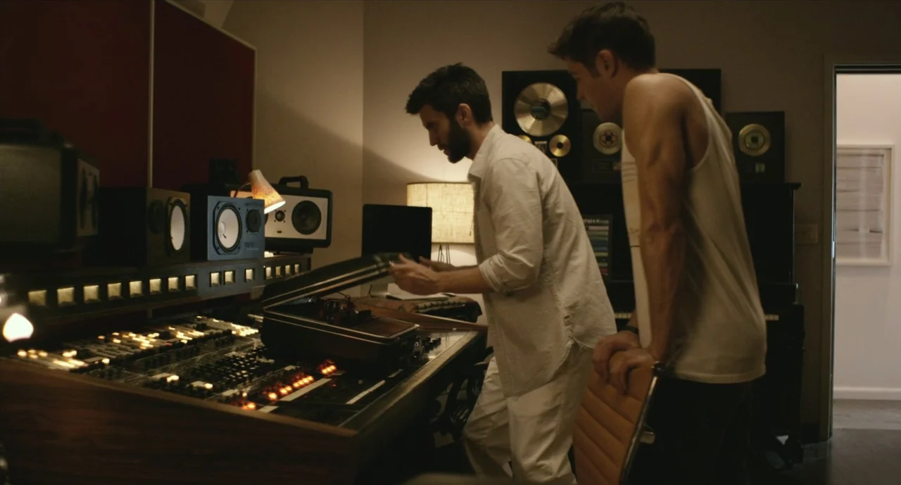 We Are Your Friends (2015) movie still: medium — A recording studio interior features a large mixing board and sound equipment. Two men stand by the…