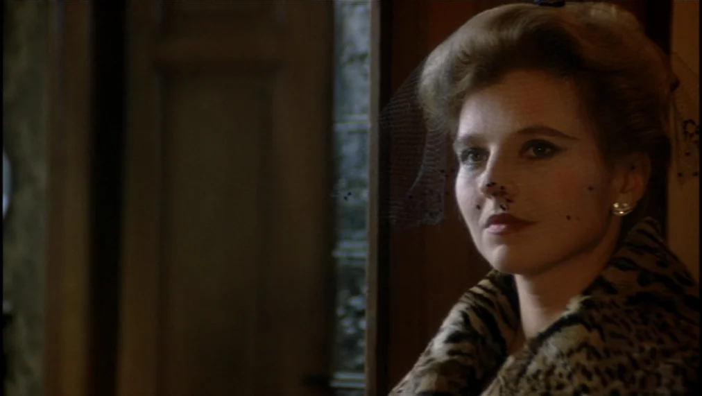 The Marriage of Maria Braun (1979) movie still: closeup — A woman stands in a wooden doorway framed against dark interior wood paneling. She wears a…