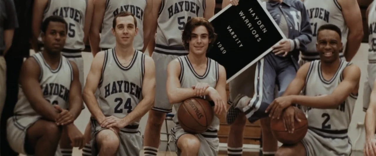 17 Again (2009) movie still: medium — A gymnasium interior features a group of basketball players posing for a team photo. The athletes wear…