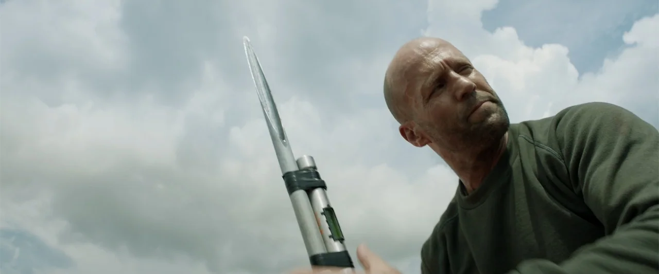 Meg 2: The Trench (2023) movie still: medium — An overcast sky serves as a bright, cloudy background for a solitary man. A middle-aged man in a…