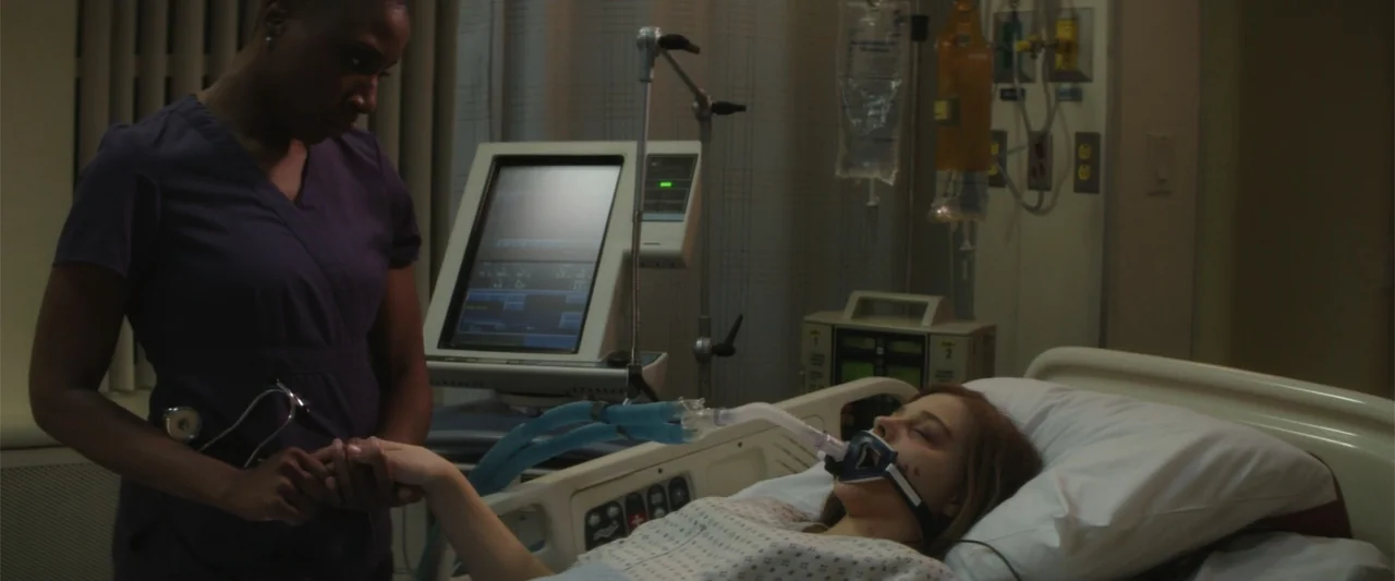 If I Stay (2014) movie still: medium — A hospital room features medical monitoring equipment and a patient connected to a ventilator. A nurse in…