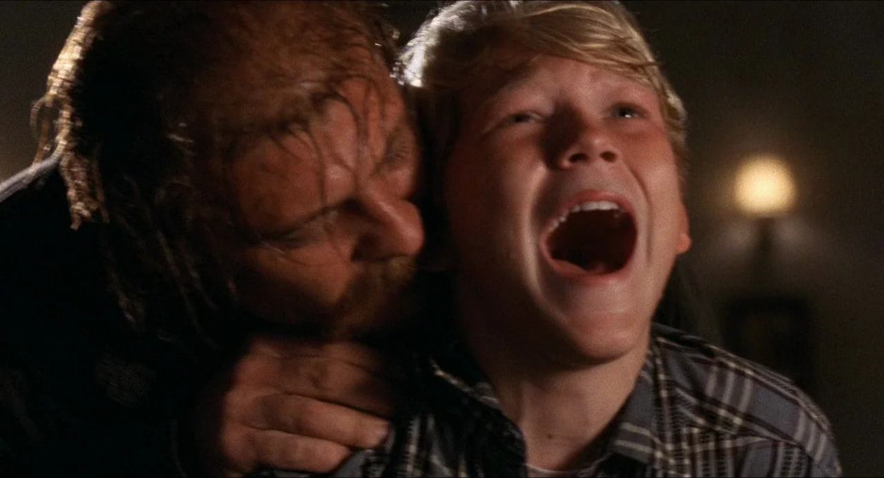 The Prince of Tides (1991) movie still: closeup — A dimly lit interior space with a faint, out-of-focus light source in the distance. An adult male…