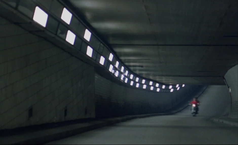 Mauvais Sang (Bad Blood) (The Night Is Young) (1986) movie still: wide — A long, curved concrete tunnel features rows of bright square overhead…
