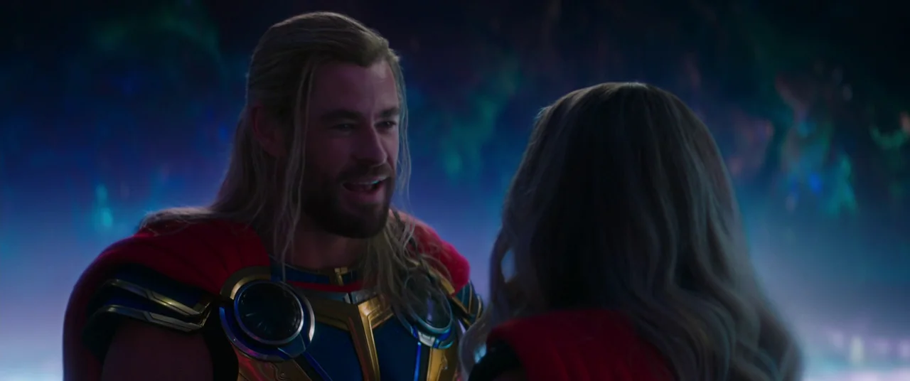 Thor: Love and Thunder (2022) movie still: medium — Two individuals stand within a swirling cosmic void characterized by nebular light. The man…