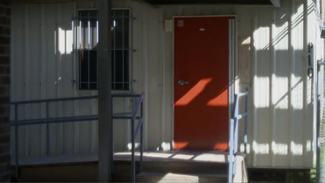 Homegrown: The Counter-Terror Dilemma (2016) movie still: medium — A prefabricated modular building features corrugated metal siding and a prominent…