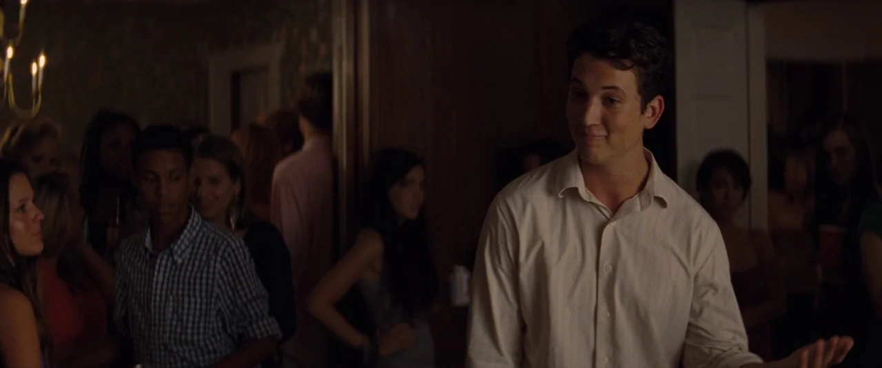 The Spectacular Now (2013) movie still: medium — A crowded domestic interior at night is filled with young adults standing in groups. A young man in…