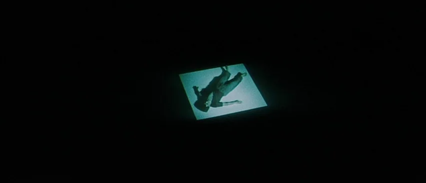 Jigoku (1960) movie still: wide — A pitch-black environment contains a single rectangular patch of light on the floor. A person lies down within…