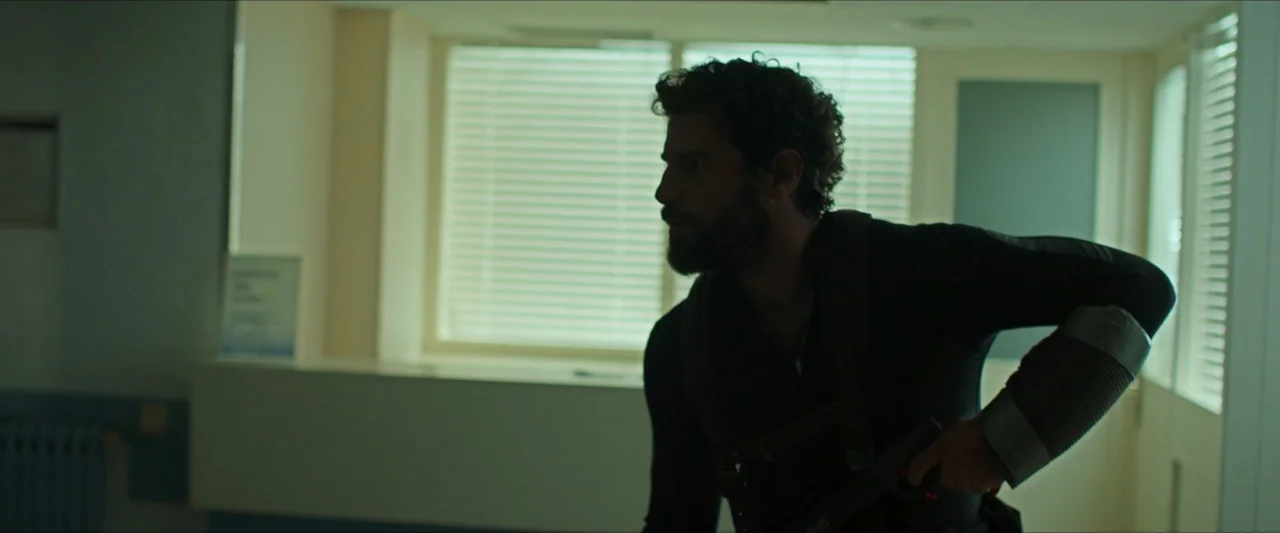 Apocalypse Z: The Beginning of the End (2024) movie still: medium — A sterile hallway features white walls and windows with closed horizontal…