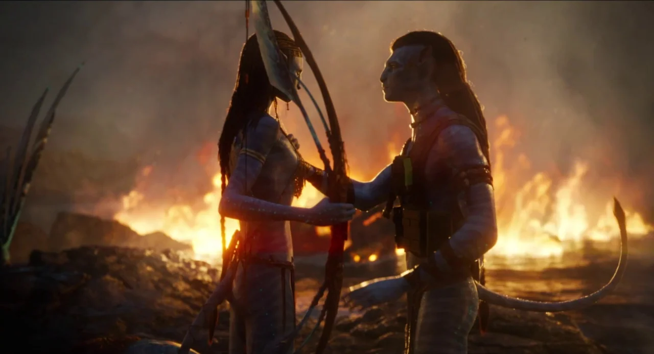 Avatar: The Way of Water (2022) movie still: fullbody — A dark volcanic landscape is illuminated by intense flames in the background. Two blue…
