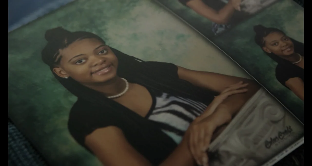 Abortion: Stories Women Tell (2016) movie still: medium — A glossy printed school portrait of a young woman rests inside a book. The photograph…