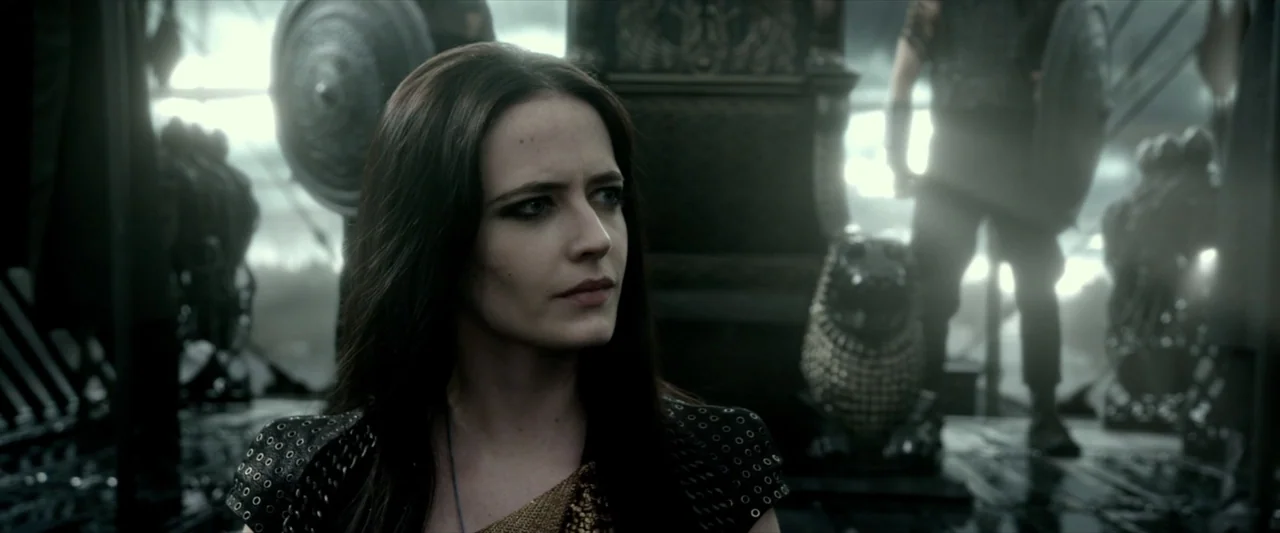 300: Rise of an Empire (2014) movie still: closeup — A dark ship deck with silhouetted figures and ornate stone statues in the background. A woman…