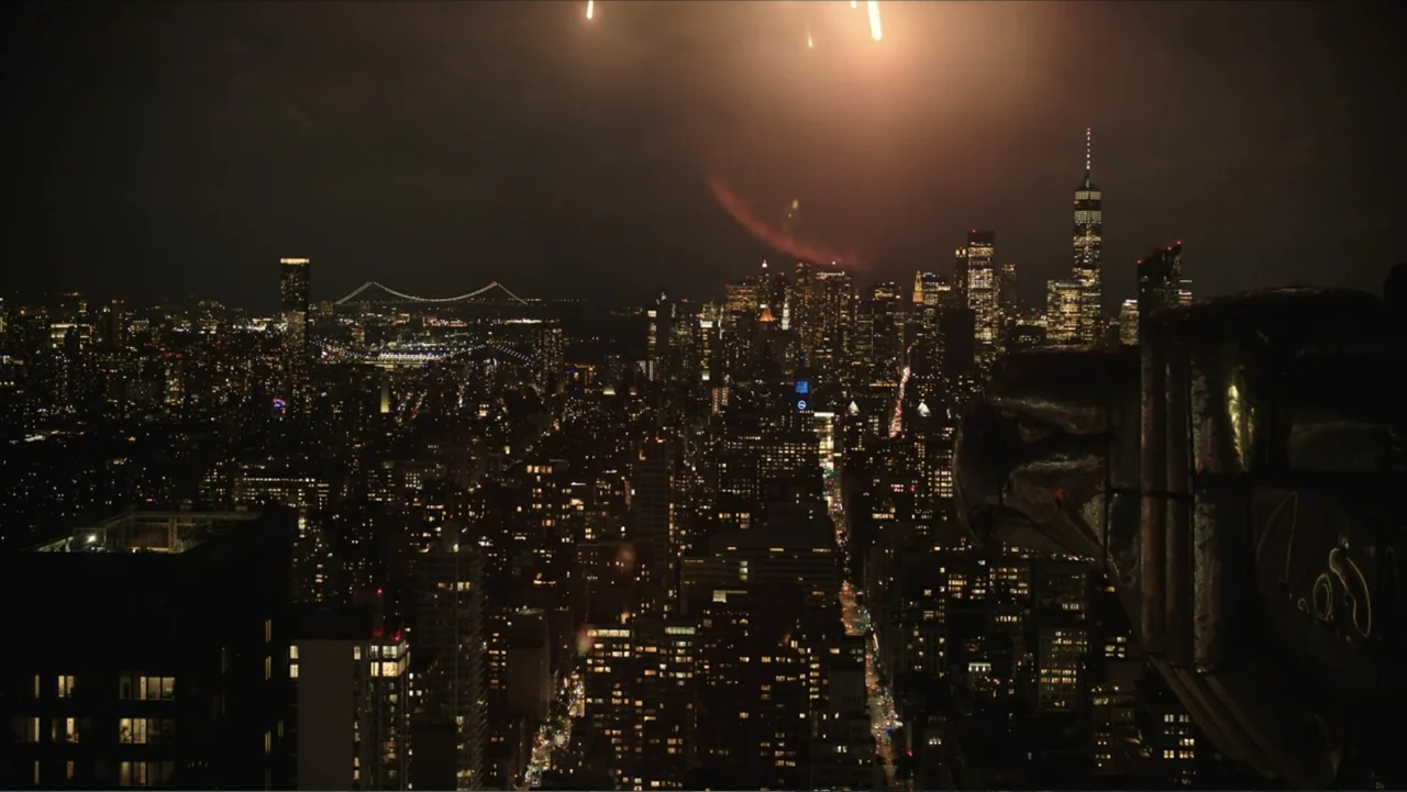 Megalopolis (2024) movie still: establishing — A dark, elevated vantage point overlooks a sprawling urban grid at night. Millions of tiny electric…