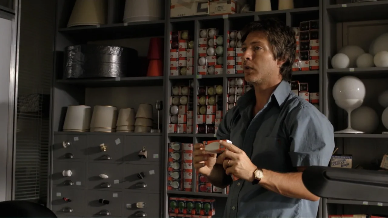 A Boyfriend for My Wife (2008) movie still: medium — Shelves packed with various lightbulbs and lampshades fill the background of a retail store. A…