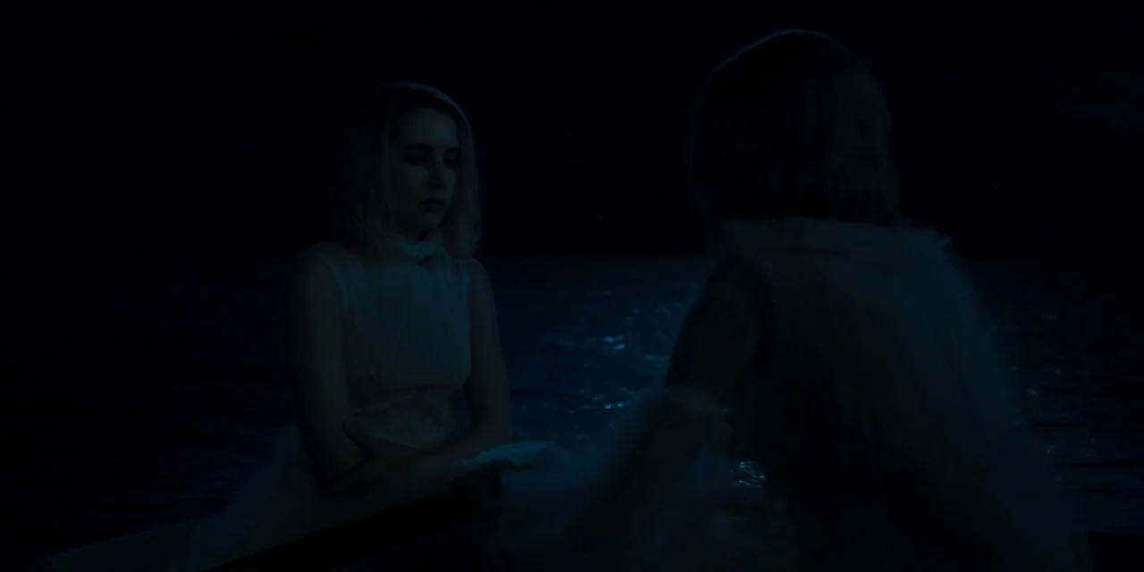 Paradise Hills (2019) movie still: medium — Two women wearing white dresses sit on the surface of dark, calm water at night. They face each other in…