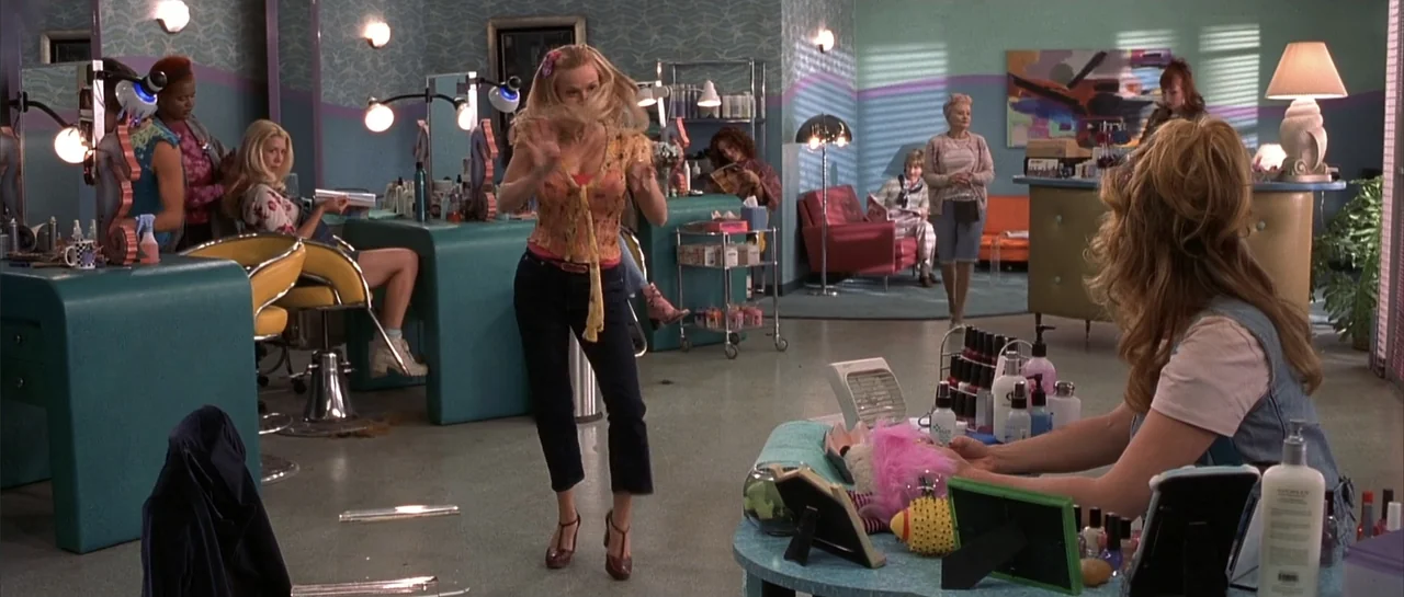 Legally Blonde (2001) movie still: fullbody — A spacious beauty salon with pastel-colored walls and multiple grooming stations arranged in rows. A…