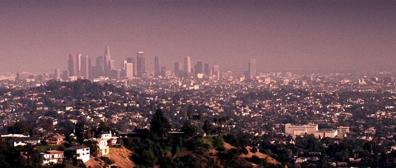 Little Birds (2011) movie still: establishing — A sprawling cityscape viewed from an elevated vantage point with distant skyscrapers. Residential…