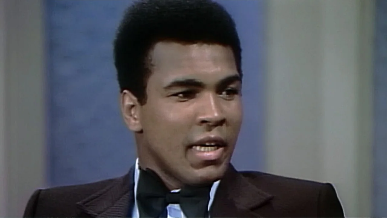 Ali & Cavett: The Tale of the Tapes (2018) movie still: closeup — A television studio set with a plain blue background behind the subject. A man in…
