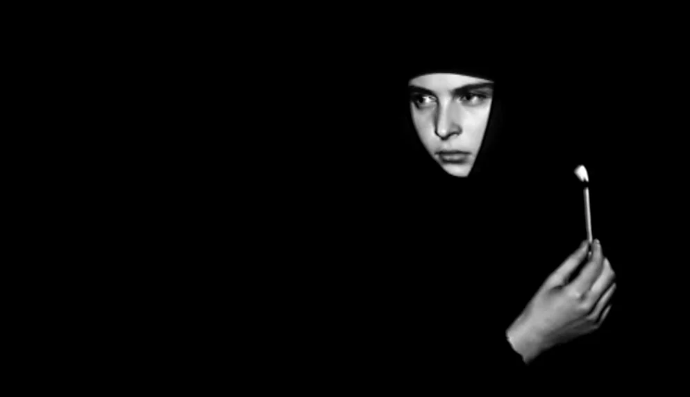 The Plea (1968) movie still: closeup — A person is in a completely dark environment with no visible background. The subject holds a small flame that…