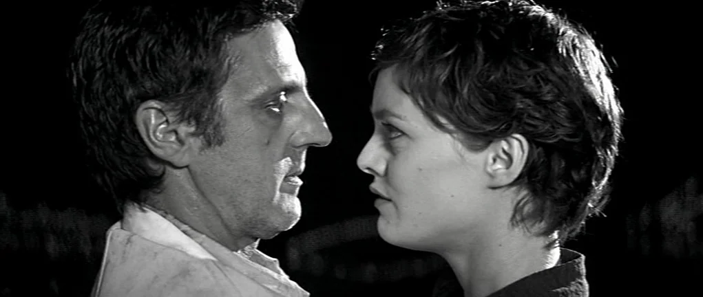 Girl on the Bridge (1999) movie still: medium — A dark night setting with two people standing facing each other in close proximity. The man and…