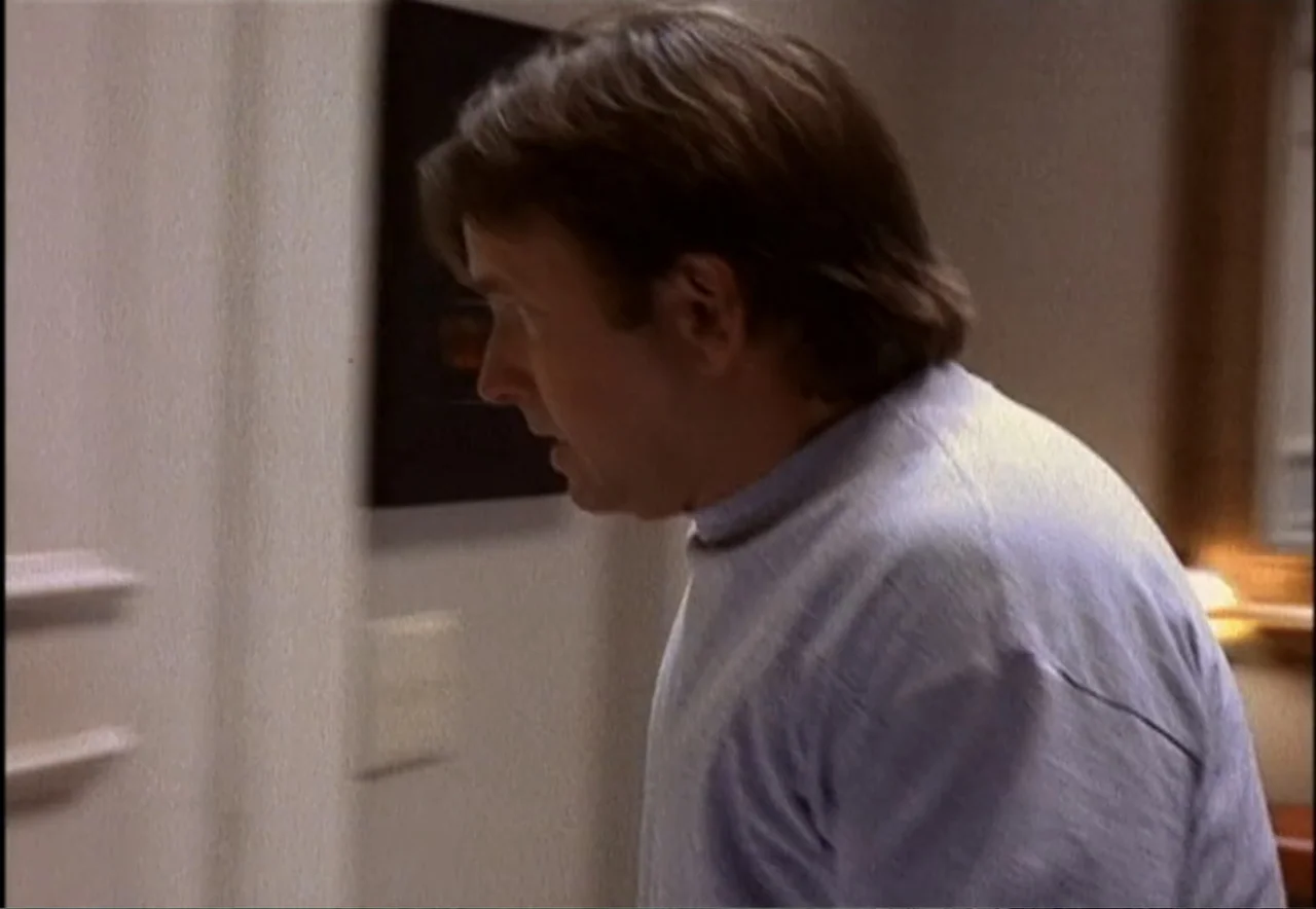Chance of a Lifetime (1998) movie still: medium — A residential hallway with neutral walls and a doorway leading into another room. A man stands in…