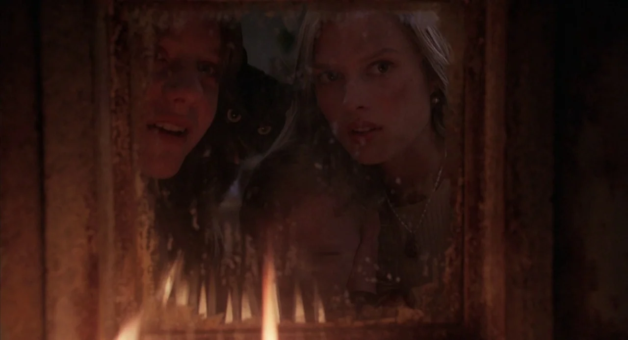 Hocus Pocus (1993) movie still: medium — A group of people watch a fire from a close perspective in a dark room. The firelight flickers on their…