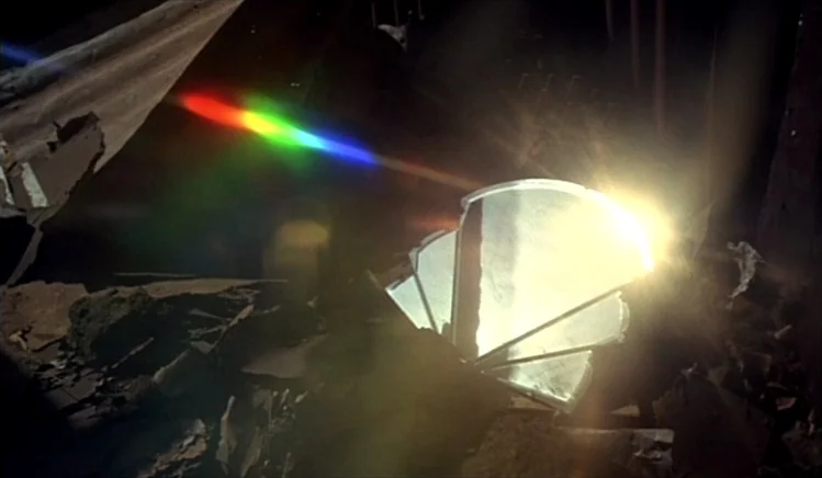 Walkabout (1971) movie still: closeup — A dark space contains a pile of debris and broken materials on the floor. A sharp shard of mirror rests…