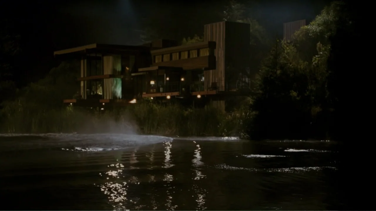 When a Stranger Calls (2006) movie still: establishing — A modern multi-story house sits at the edge of a dark still lake. The structure is lit by…