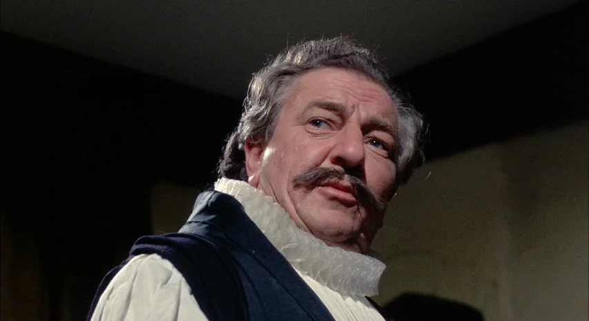 Witchfinder General (1968) movie still: closeup — The interior of a room is cast in deep shadow. An older man with a mustache looks off-camera.
