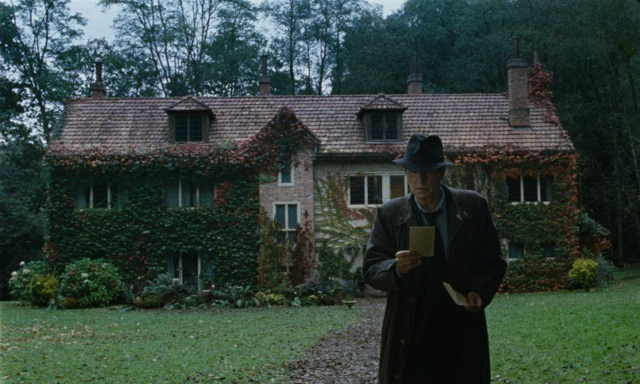 Close Your Eyes (2023) movie still: fullbody — A two-story brick country manor is covered in thick green and autumn-colored vines. An older man…