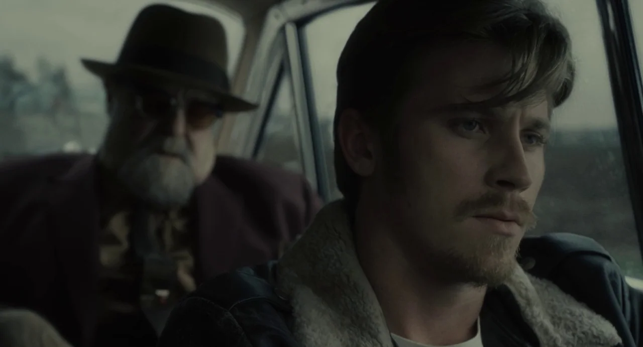 Inside Llewyn Davis (2013) movie still: medium — The interior of a moving 1970s vehicle shows a driver and passenger side-by-side. The young driver…